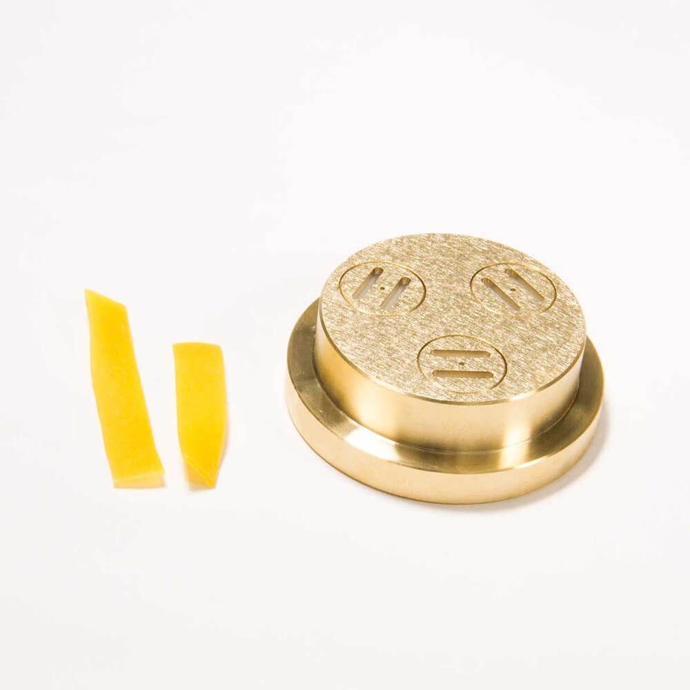 Nudelmatrize Nr. 21 für Bandnudeln neben zwei Bandnudeln vor einem weißen Hintergrund.