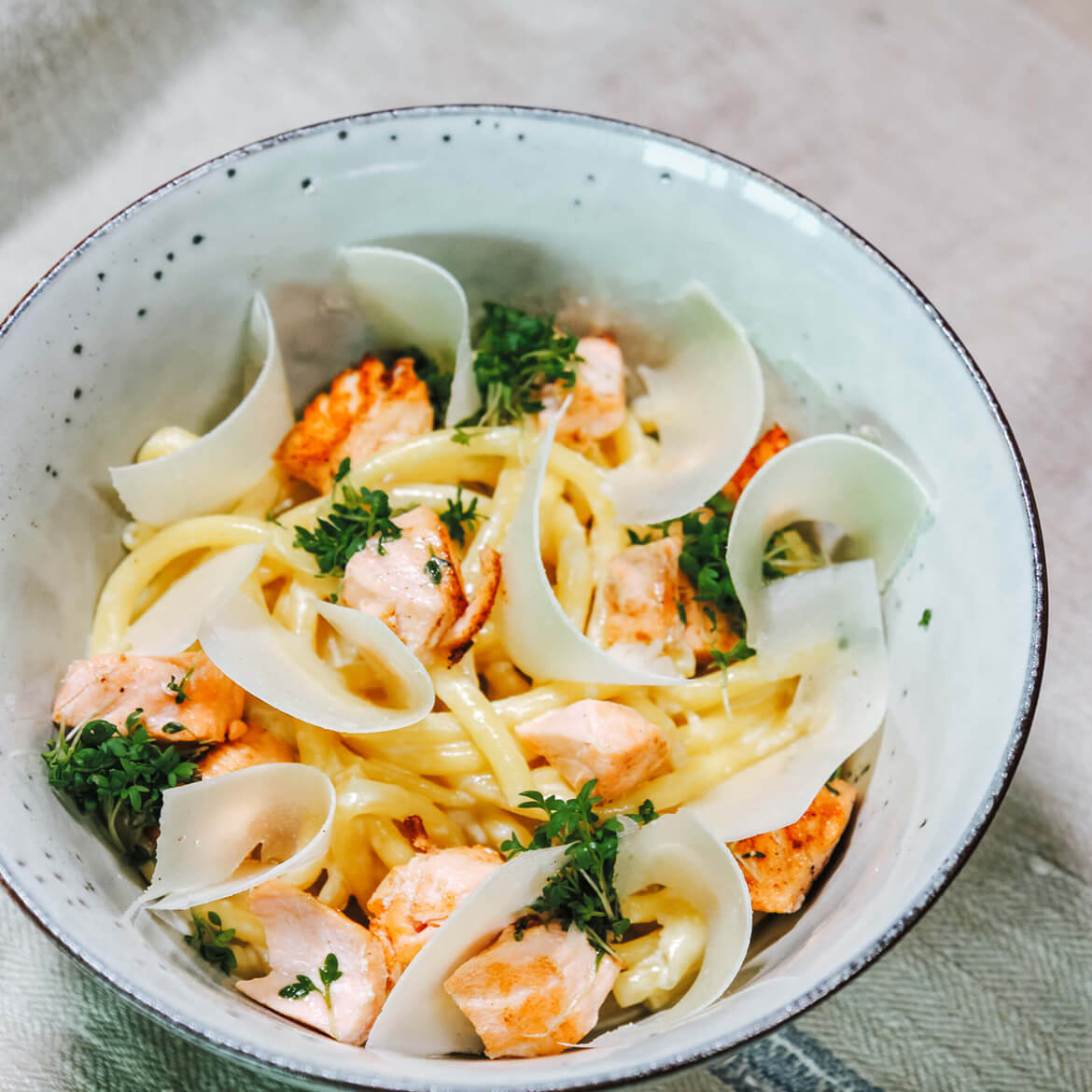 Rezept für Makkaroni mit Lachs-Sahnesoße selbstgemachte Makkaroni mit einer Lachs-Sahnesoße und frischem Parmesan, serviert in einer hellblauen Schüssel