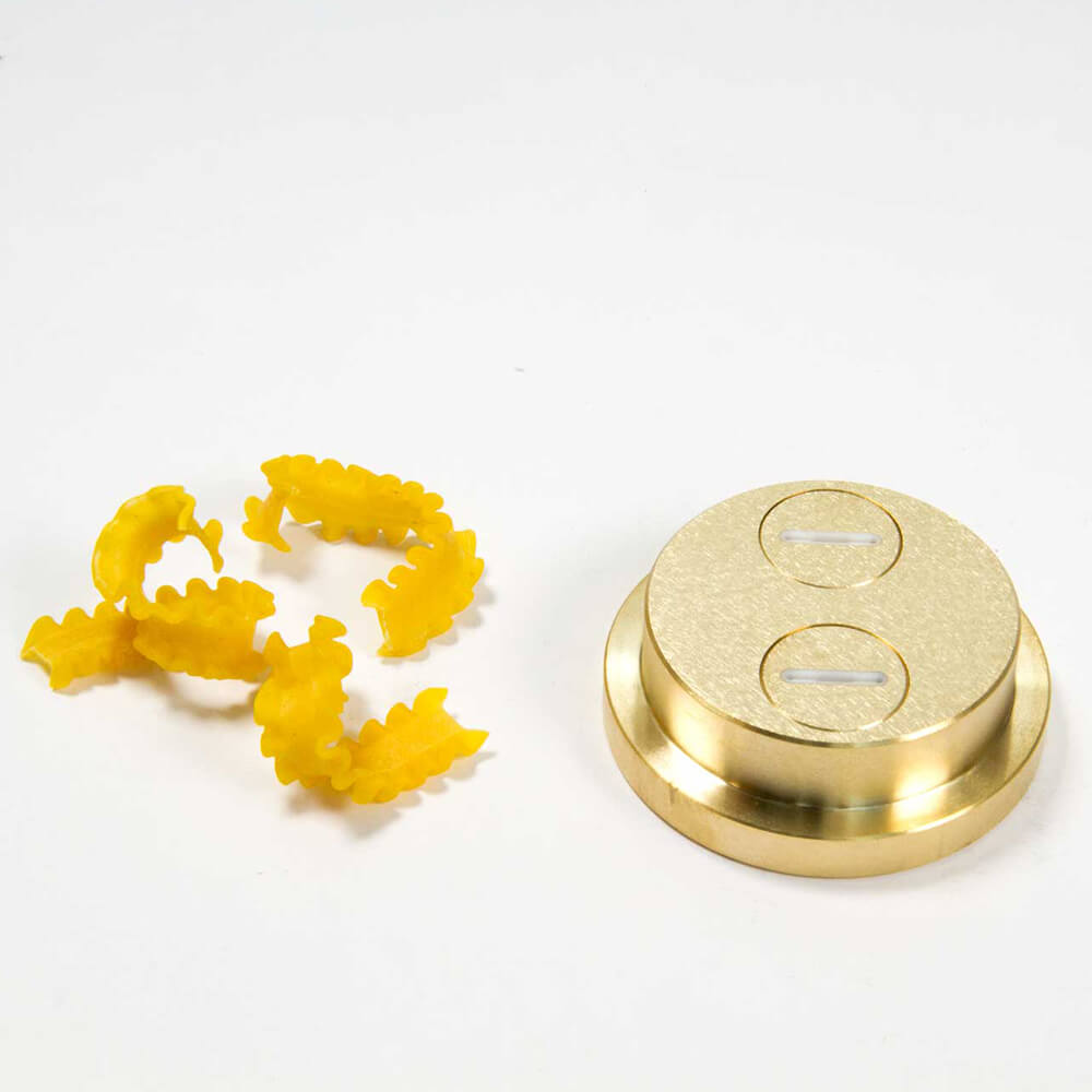 Nudelmatrize Nr. 56 für Mafalde / Gewellte Bandnudeln neben einigen gewellten Bandnudeln vor einem weißen Hintergrund.