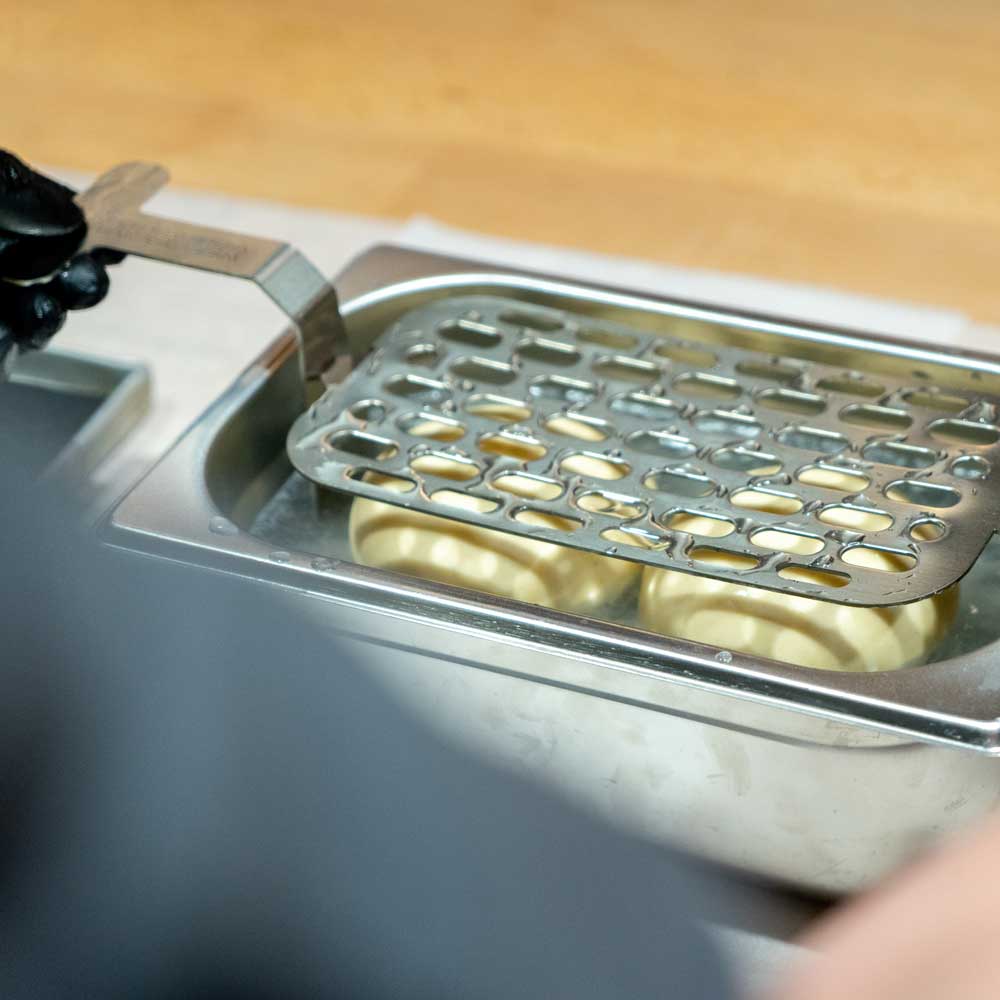 Sauberes und gleichmäßiges Belaugen von Brezeln & Backwaren Brötchen werden in Lauge getaucht