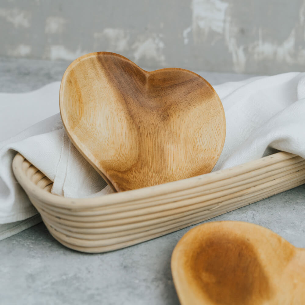 Servierteller - Herz - 17 cm Servierteller aus Holz in Herzform die in einer Peddigrohrform liegen