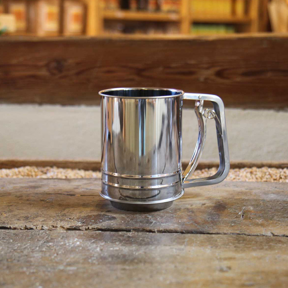 Einhandmehlsieb Einhandmehlsieb 10cm auf einem Holzbrett