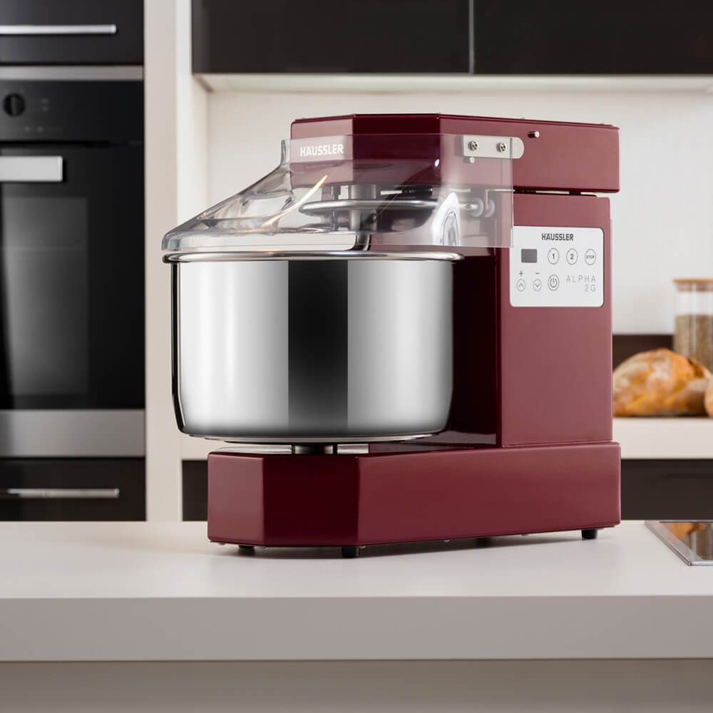 Teigknetmaschine Alpha in Weinrot auf einer Arbeitsfläche 