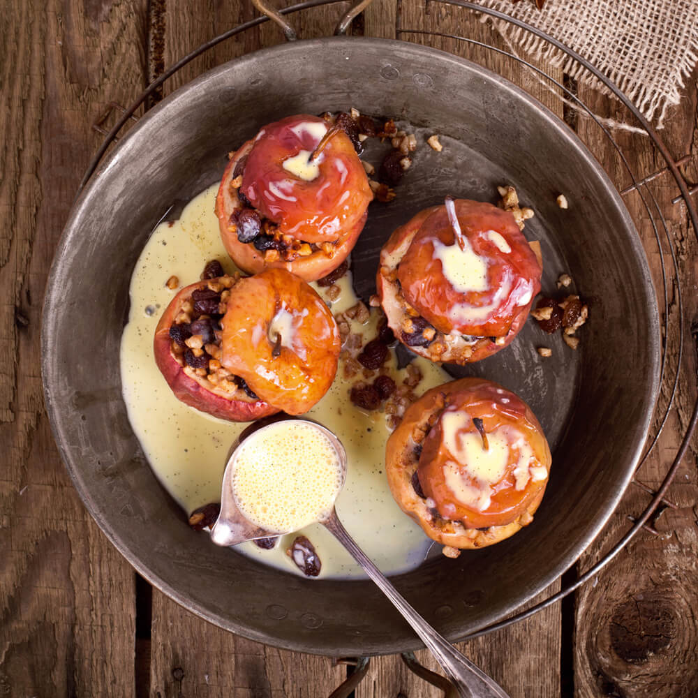 Rezept für Bratapfel mit Vanillesoße 4 Bratäpfel in einer Rundform mit einer Füllung aus Rosinen, Marzipan und Nüssen an einer selbstgemachten Vanillesoße