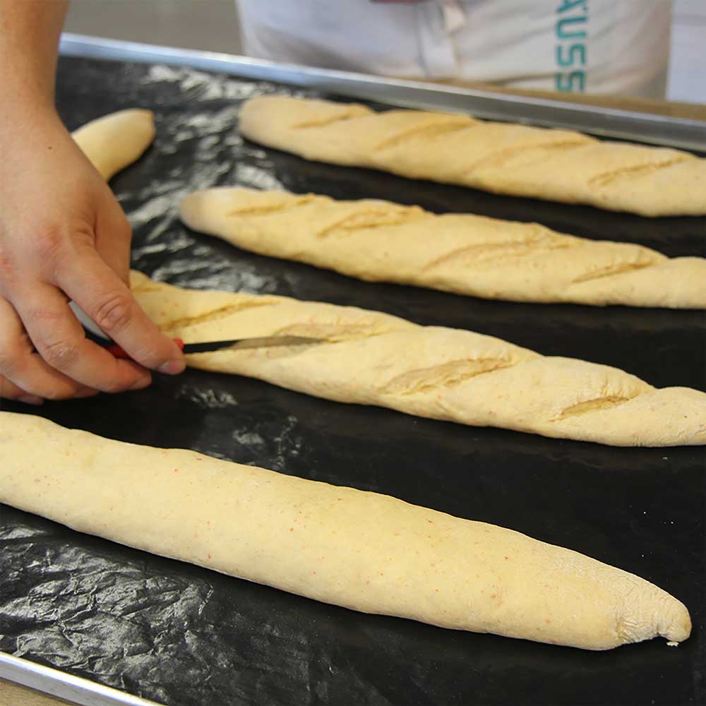 Brötchenritzmesser schneidet Teiglinge ein vor dem Backen Brötchenritzmesser schneidet Teiglinge ein vor dem Backen