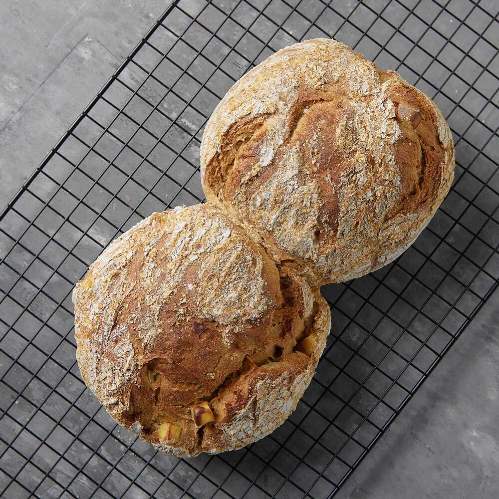 Kartoffelbrot aus Kartoffelbrotmehl Frisch gebackenes, würziges Kartoffelbrot auf einem Trüffelgitter auf einer Küchenarbeitsplatte.