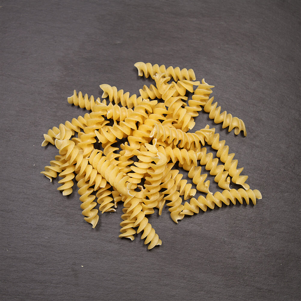 Dinkelgrieß-Nudeln mit besonders feine Qualität Spirelli auf einer schwarzen Arbeitsfläche