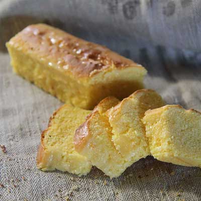 Aufgeschnittener Gugelhupfkuchen liegt auf einem beigen Leinentuch.