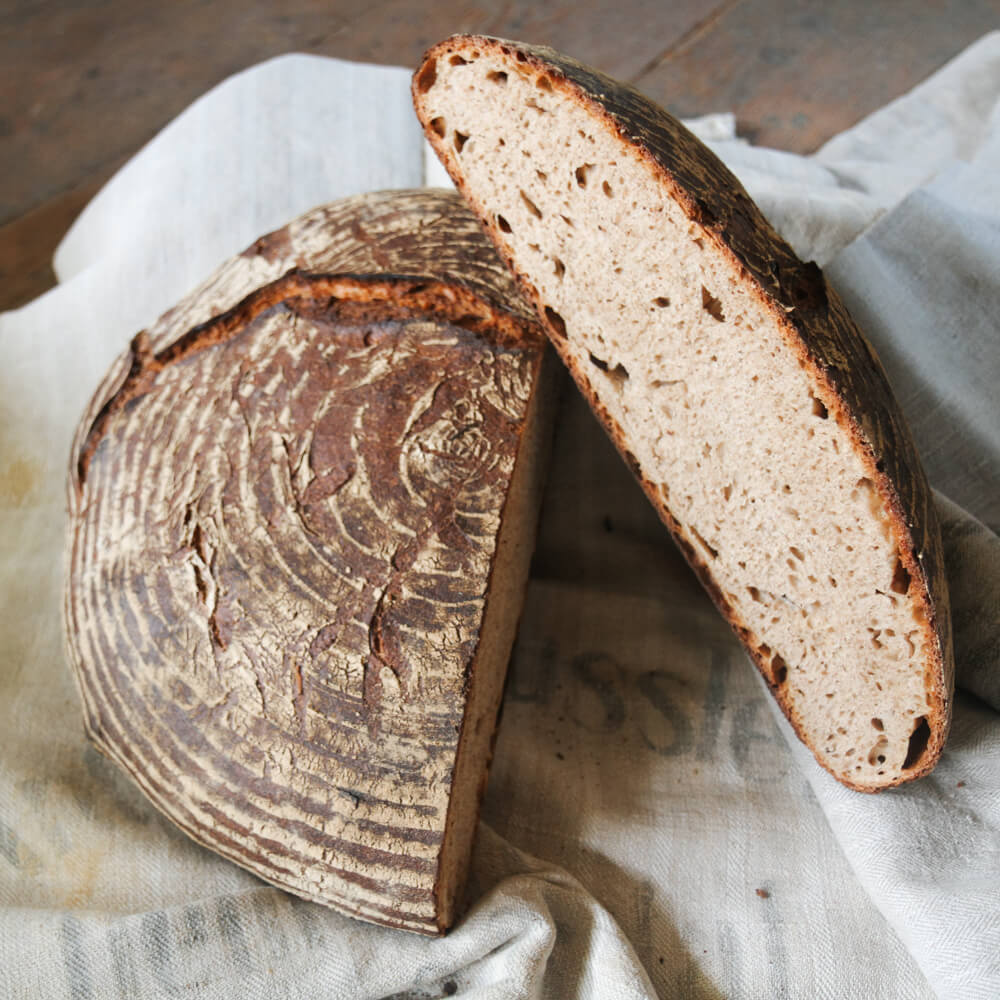 großes flaches Brot aufgeschnitten auf einem grauen Tuch