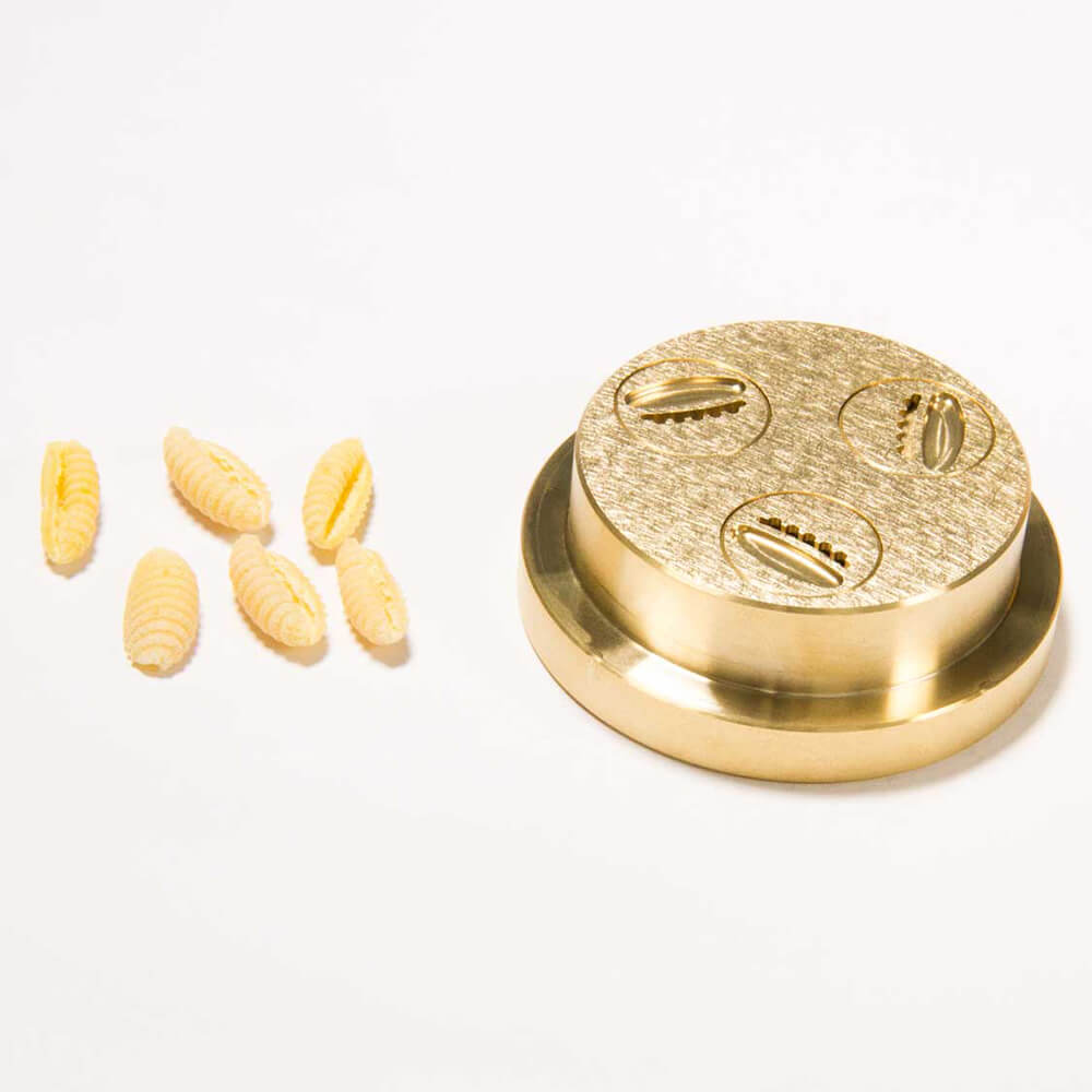 Matrize Nr. 340 - Gnocchetti Nudelmatrize Nr. 340 für Gnocchetti-Nudeln neben einigen Gnocchetti-Nudeln vor einem weißen Hintergrund.