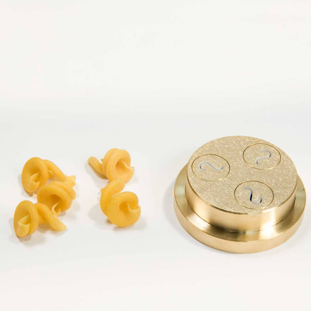 Nudelmatrize Nr. 370 für Schneckle-Nudeln neben einigen Schneckle-Nudeln vor einem weißen Hintergrund.