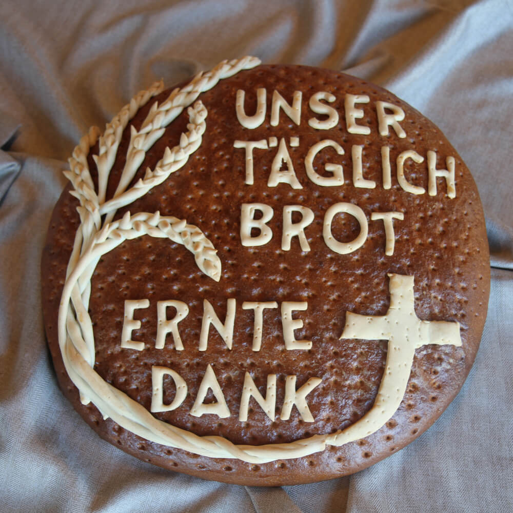 Rezept für Ernte-Dank Brot schön verziertes Ernte-Dank Brot mit Ähren, Kreuz und der Aufschrift unser Täglich Brot