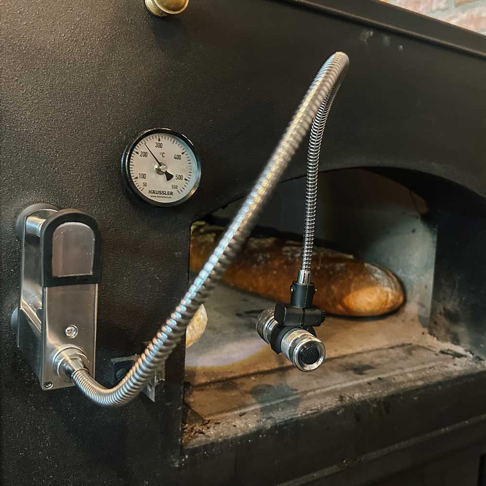 Grill- und Backofenleuchte mit Klemmhalterung Grillleuchte die über einen Magnet an einem Holzbackofen befestigt wird. Sie leuchtet in den Ofen Innenraum in dem gerade Brot gebacken wird.