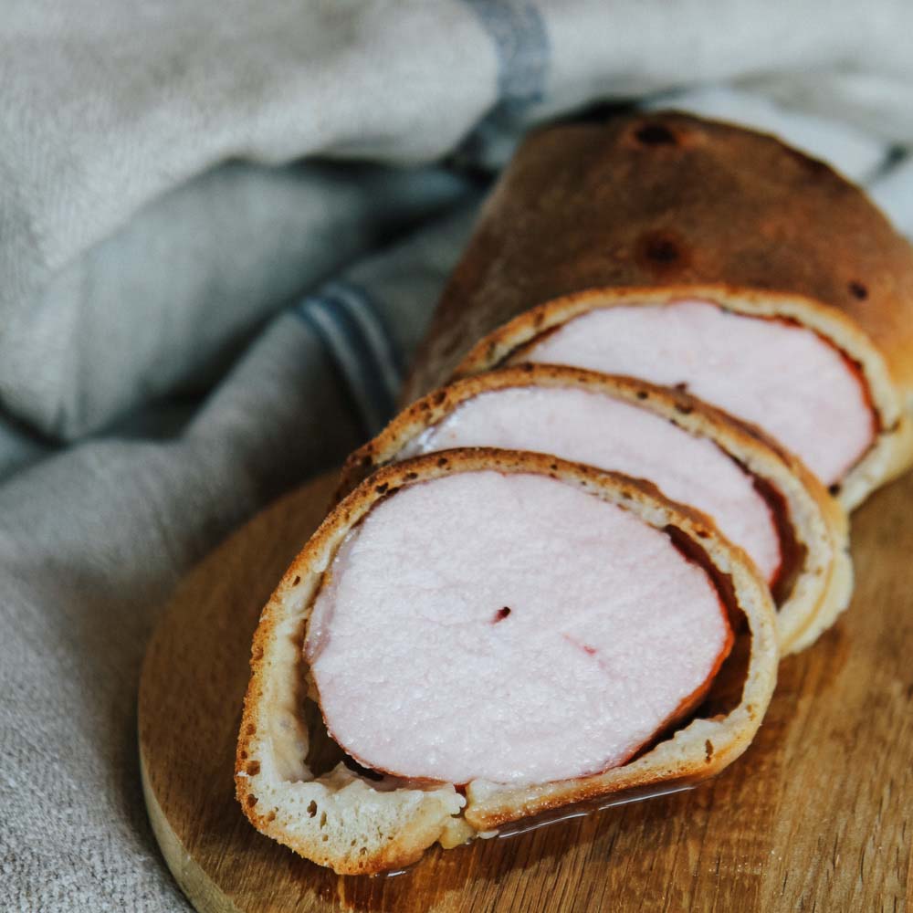 Rezept für Kassler im Brotmantel saftiges Kassler im Brotmantel gebacken, serviert auf einem Holzbrett