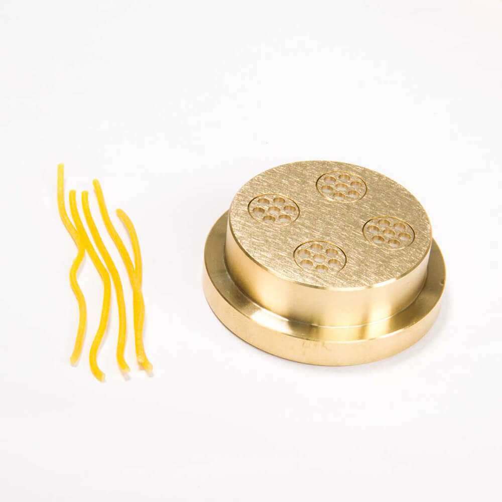 Nudelmatrize Nr. 4 für Spaghetti neben 5 Spaghetti-Nudeln vor einem weißen Hintergrund.